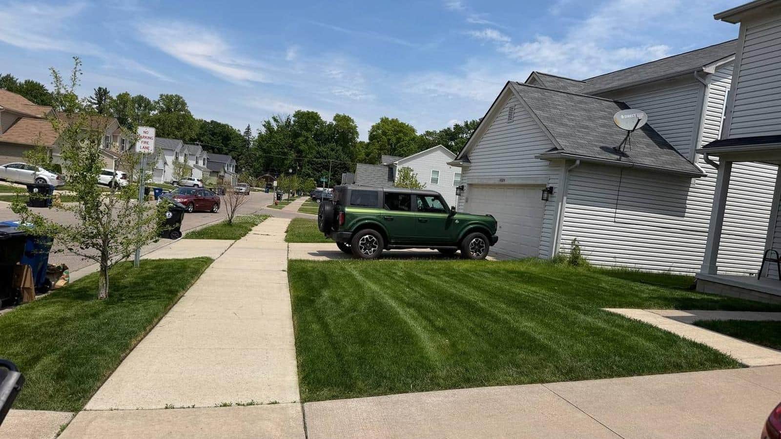Freshly cut and striped front lawn serviced by Woolfman Lawn Services in metro Detroit
